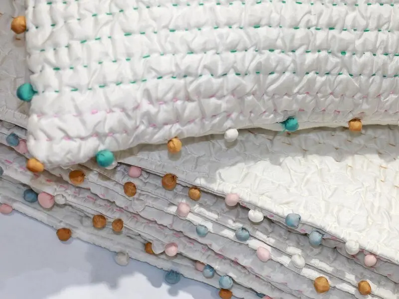 soft touch quilt with stitching details and pompoms170x220cm with one cushion cover