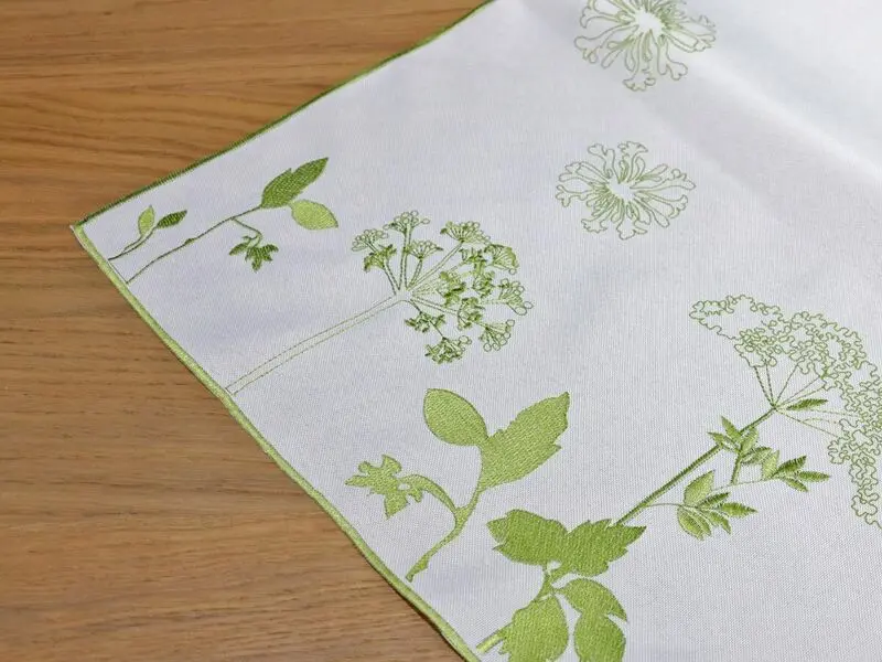 white table runner with green floral embroidery